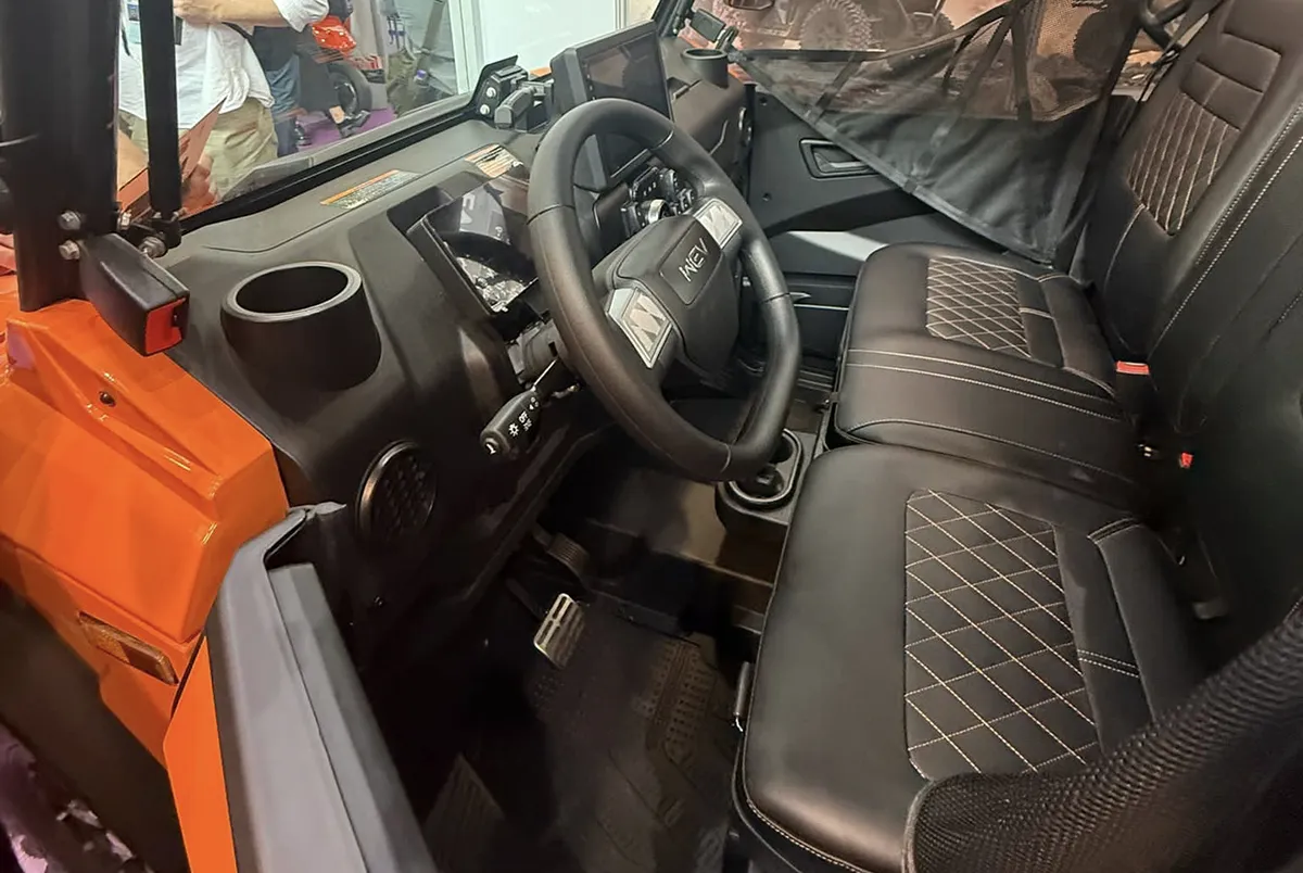 Förarmiljö i WEV E30 med ratt, instrumentpanel och två sittplatser.