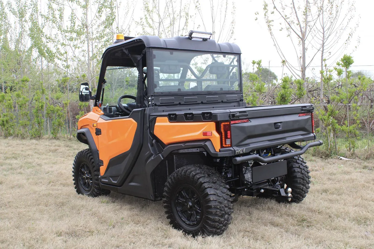 Orange WEV E30 elektrisk UTV med lastflak, fotograferad snett bakifrån.