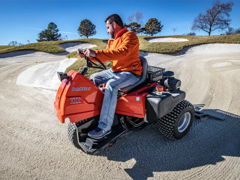 Smithco Sand Star III bearbetar sanden i en golfbunker.